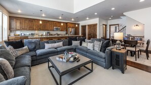 Ein großzügiges Wohnzimmer mit Ecksofa, Couchtisch und Essbereich mit Tisch und Stühlen.