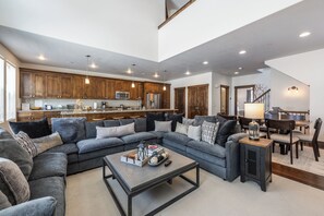 Ein großzügiges Wohnzimmer mit Ecksofa, Couchtisch und Essbereich mit Tisch und Stühlen.