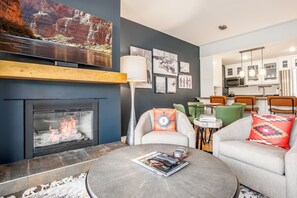 Ein modernes Wohnzimmer mit Kamin, Essbereich und Küche.