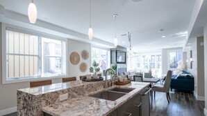 A modern kitchen with granite countertops, a built-in sink, and pendant lighting. - Steps from Town Lift & Main Street! Luxe amenities! (Park City)