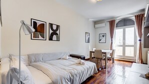 Ein modernes Hotelzimmer mit Bett, Schreibtisch, Stuhl und Bildern an den Wänden.
