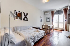 Ein modernes Hotelzimmer mit Bett, Schreibtisch, Stuhl und Bildern an den Wänden.
