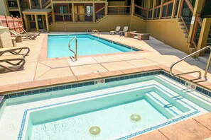 Ein rechteckiger Pool mit Sprungbrett und Liegestühlen.