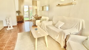 A spacious living area with a sofa, a dining table, and a ceiling fan. - Large terrace 140m from the Mediterranean Sea (Cabo de Palos)