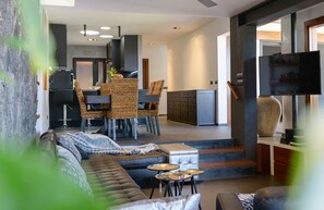 A modern living room with a sofa, a dining area with wicker chairs, and a kitchen in the background. - Luxury & Harmony, Top luxury villa in playa blanca (Playa Blanca)