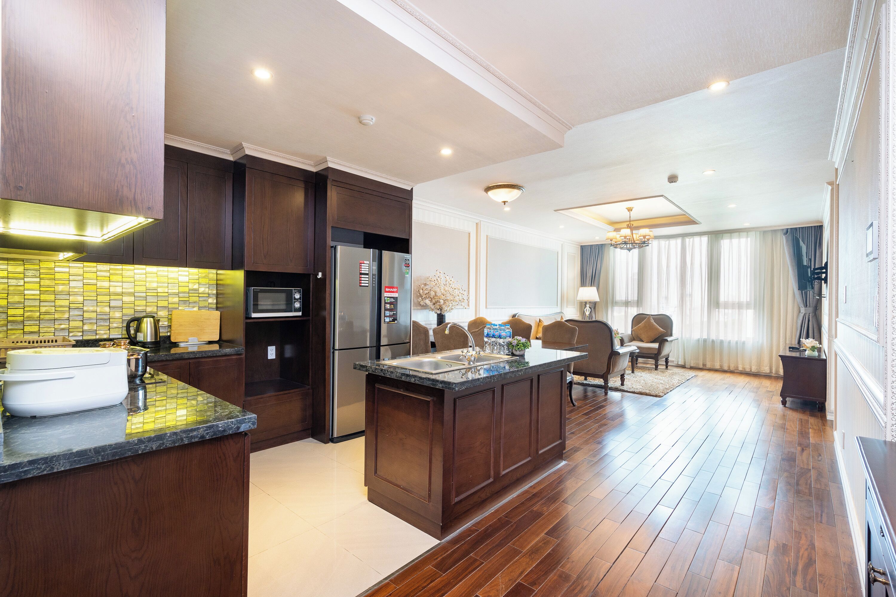 A modern kitchen with dark wood cabinets, a central island, and a built-in oven.