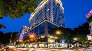 Ein mehrstöckiges Hotel mit modernem Design, das eine markante Eingangsfront und eine gut beleuchtete Fassade aufweist.