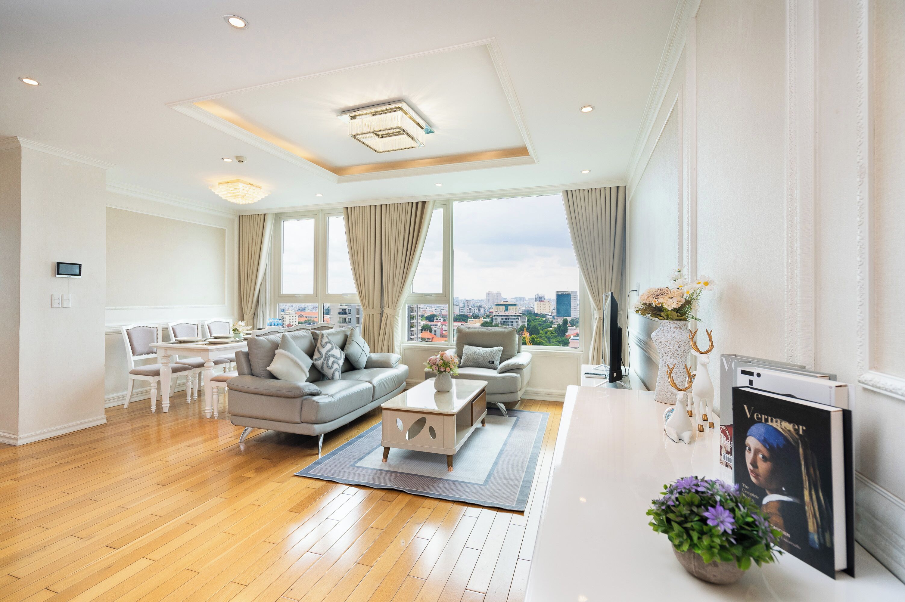 A modern living room with a sofa, coffee table, and a view of the city.