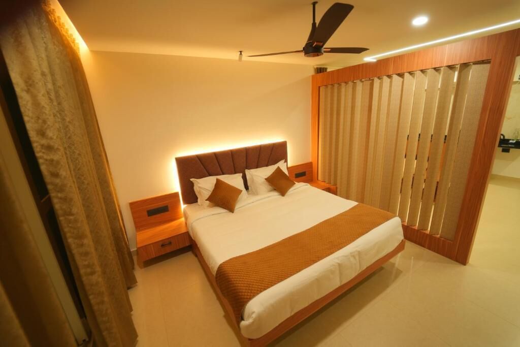 Un dormitorio con cama, mesitas de noche, ventilador de techo y una puerta corrediza con cortinas.