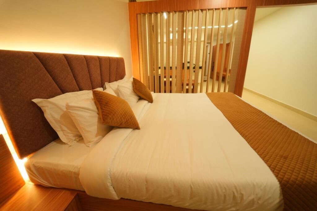 A neatly made bed with a headboard, pillows, and a blanket.