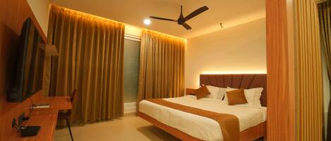 Una habitación de hotel moderna con una cama grande, un escritorio y un ventilador de techo.