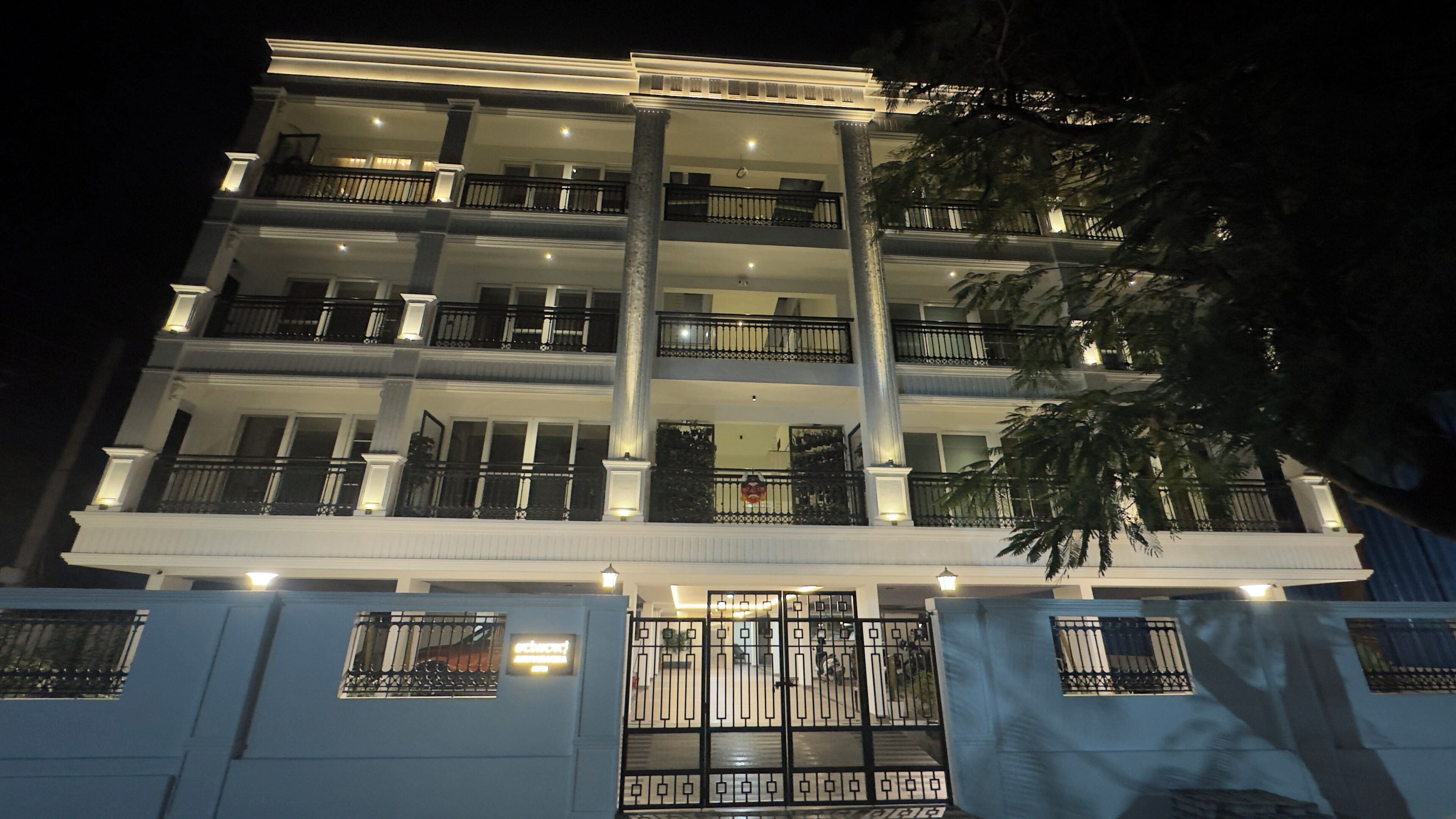 A multi-story building with balconies and a gated entrance.