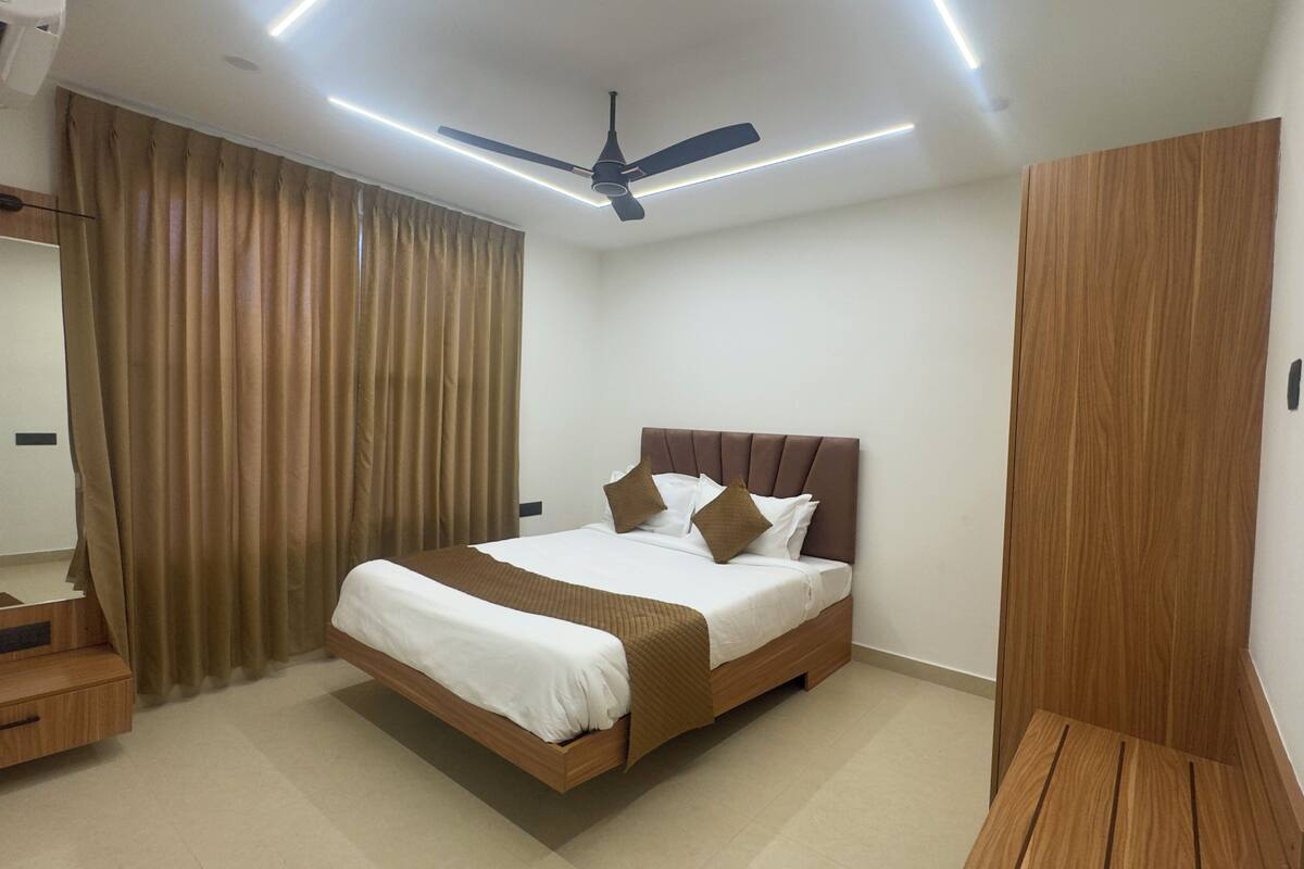 Un dormitorio moderno con cama, ventilador de techo y armario.