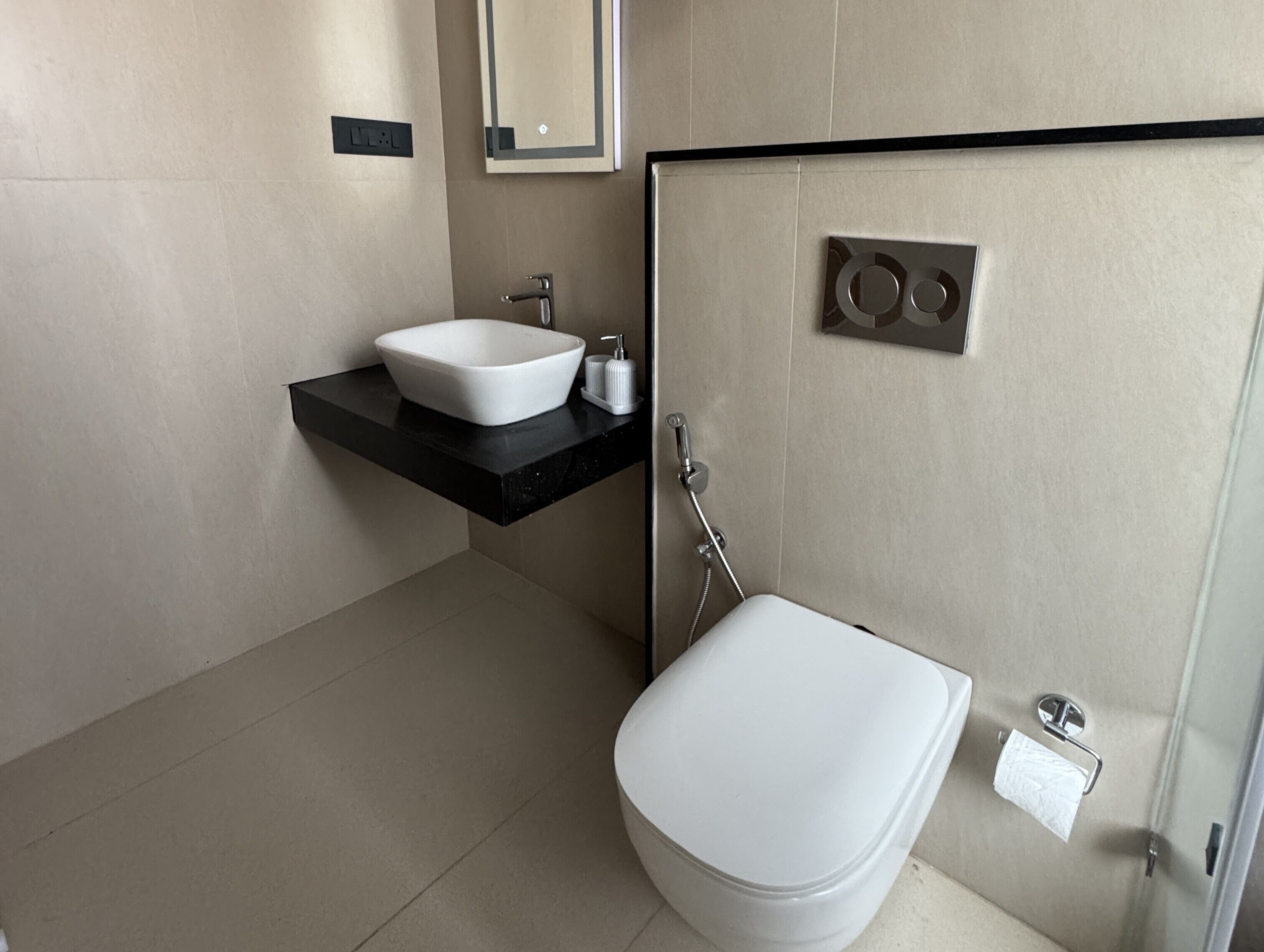 A modern bathroom with a white sink, a toilet, and a shower.