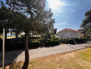 Ein Wohngebiet mit einem Haus mit Ziegeldach, umgeben von Bäumen und blauem Himmel.