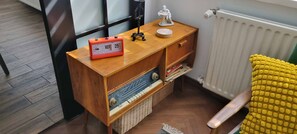 A wooden console table with a retro-style alarm clock, a small statue, and a plate. - 2-bedroom apartment in wonderful vintage Sofia with AC and comfort (Sofia)