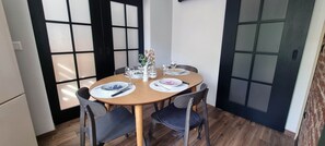 Un coin repas comprenant une table ronde, des chaises et un vase décoratif.