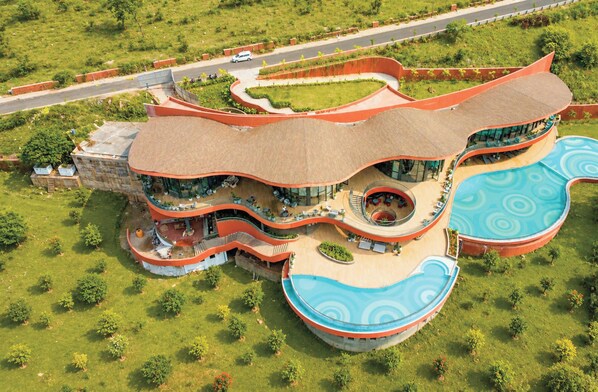 Un hôtel moderne doté d’une architecture originale aux lignes courbes, d’une piscine centrale et d’un jardin aménagé.