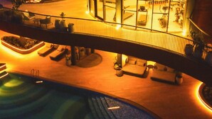 A rooftop pool area with a bridge, lounge chairs, and a dining area. - Tomorrow Land by Miros - Anjarle (Dapoli)