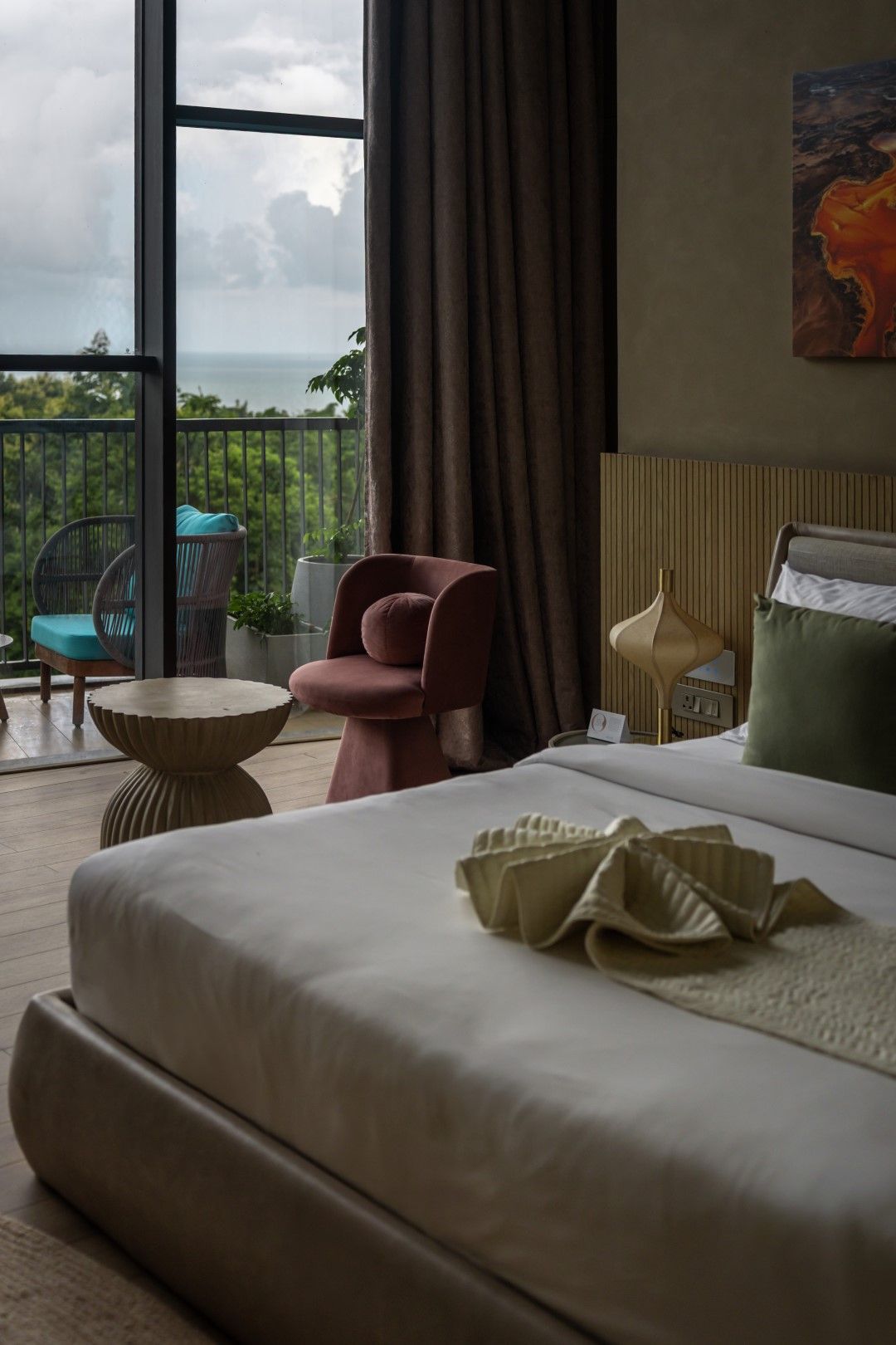 Une chambre d’hôtel avec un lit, une chaise, une petite table et une vue sur l’extérieur.