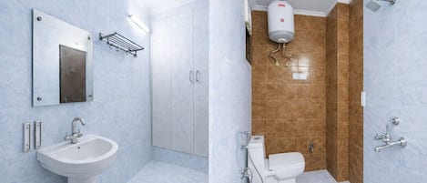 Une salle de bain équipée d’un lavabo, d’un miroir, d’un meuble de rangement, de toilettes, d’une douche et d’un chauffe-eau.