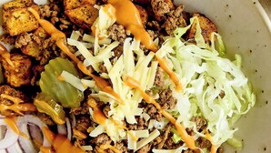 Un plato de comida con diferentes ingredientes y salsa.