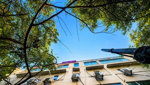 Un edificio de varios pisos con amplias ventanas y unidades de aire acondicionado.