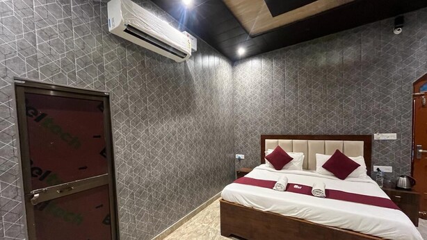 Habitación de hotel con cama, armario, equipo de aire acondicionado y pared de azulejos.