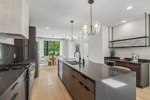 Una cocina moderna con una isla central, electrodomésticos de acero inoxidable y una zona de comedor con vistas.