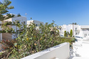 A residential area with white buildings, a balcony, and a clear blue sky. - Mary & Jo's Apartments (Naxos)