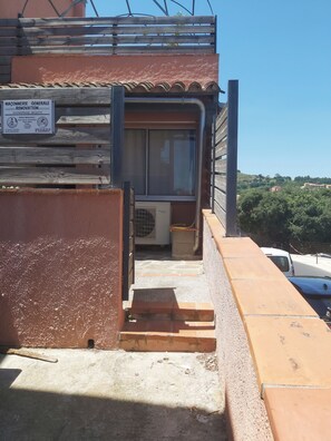 Ein Gebäude mit einem Schild, das auf ein Bauunternehmen hinweist, einem Fenster und einer Treppe zu einer Klimaanlage.