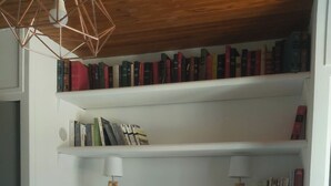 A bedroom with a bed, two bedside tables, a bookshelf, and a pendant light. - 2-bedroom apartment with terrace 5 minutes from the center and beaches (Collioure)