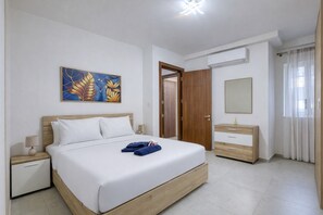 Ein Schlafzimmer mit Bett, Nachttisch, Kommode, Spiegel und einem Bild an der Wand.