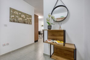 Ein Flur mit einem Holzkonsolentisch, einem Spiegel und einem Blumenbild.