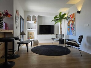 A modern living room with a flat-screen TV, a round black rug, and a large plant. - CASA MARBELLA OJEN 8 km from Marbella and SEA (Ojén)