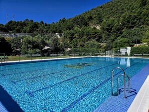 A clear blue swimming pool with a tiled deck, surrounded by lush greenery and a hilly backdrop. - CASA MARBELLA OJEN 8 km from Marbella and SEA (Ojén)