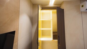 A room with a built-in shelving unit, a recessed ceiling light, and a wall-mounted air conditioning unit. - Nirrtul Sapphire Studio Apartment Specious Cozy & Quite (Surat)