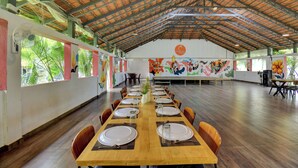 Un salón amplio con techos altos y una larga mesa de comedor dispuesta para una comida.