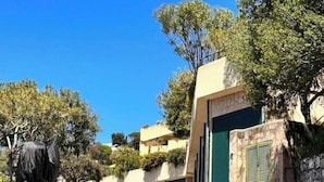 Un espace de stationnement avec un bâtiment doté d’une porte verte et d’un mur en pierre.