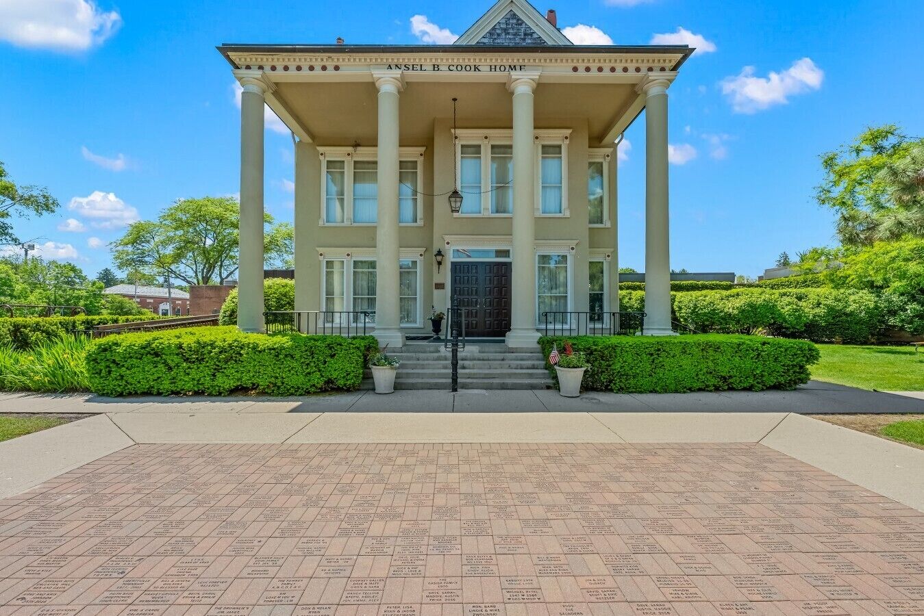 A stately building with a grand entrance, columns, and a nameplate reading 'Ansel B. Cook Home.'