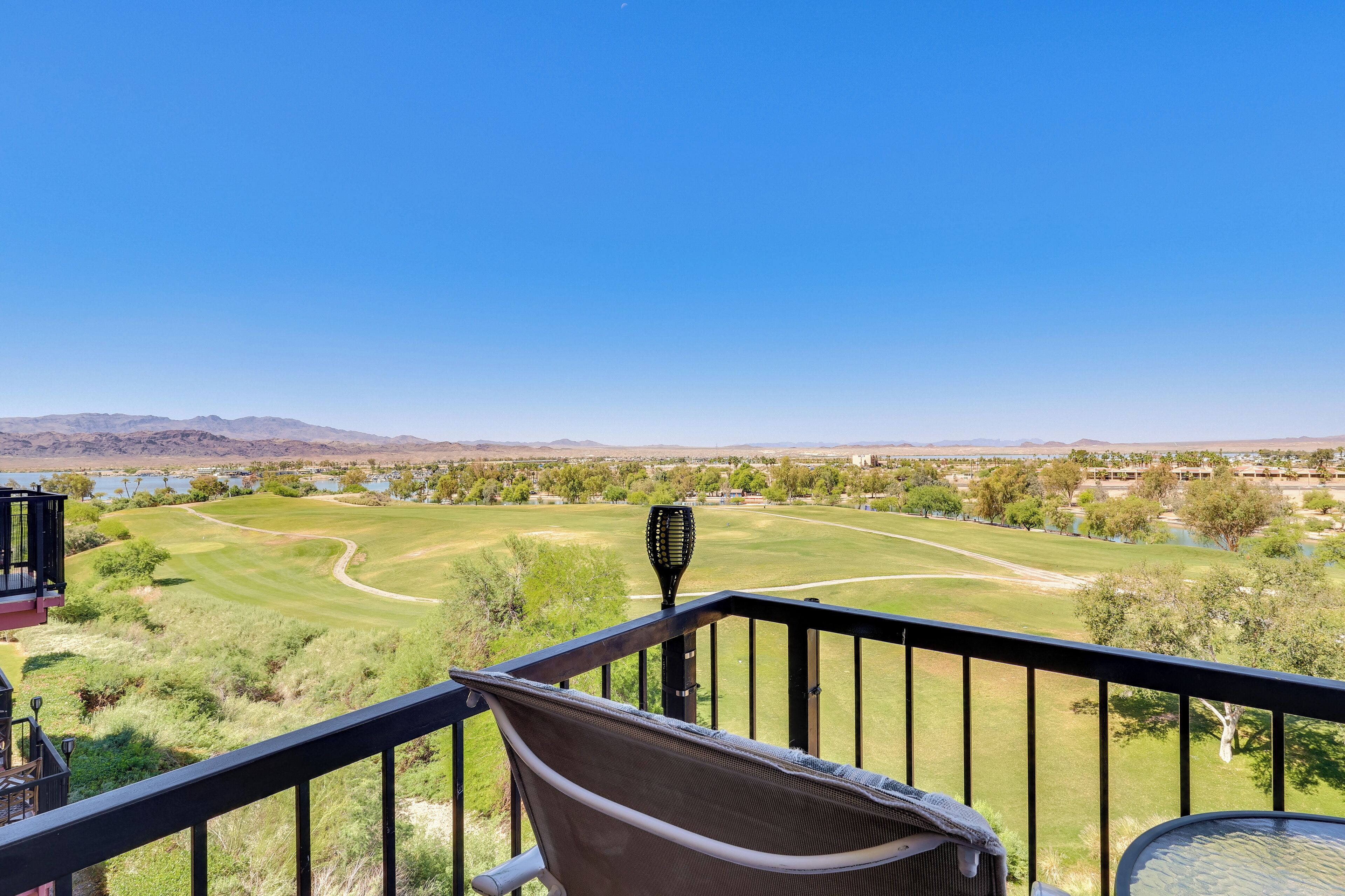 Un balcón con vistas a un campo de golf, una silla y una mesa.