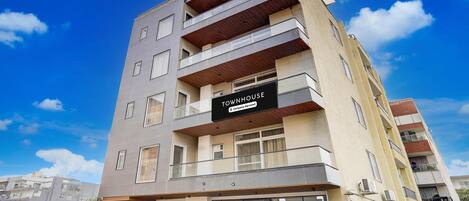 Een meerlaags gebouw met een bord waarop 'Townhouse & Company Services' staat.