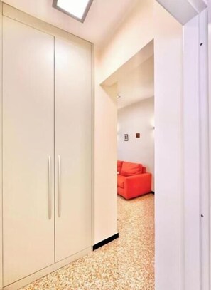 Une pièce avec une armoire, un canapé rouge et un tapis à motifs.