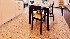 Cocina compacta con comedor, ventilador de techo y ventana.