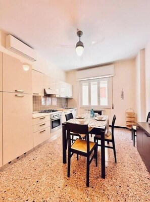 Une cuisine de taille réduite avec un coin repas, un ventilateur de plafond et une fenêtre.