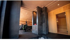 Ein modernes Fitnessstudio mit Trainingsgeräten, einer Holzwand und einem großen Fenster.