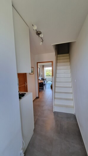 A narrow hallway leading to a dining area with a staircase. - At the gates of Biarritz, swimming pool, tennis court, golf course, children's playground, beaches within walking distance (Bidart)