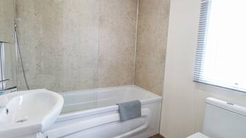 Ein Badezimmer mit einer Badewanne, einem Waschbecken und einer Toilette.