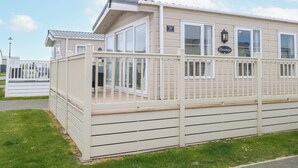 A single-story building with a white exterior, large windows, and a balcony. - 59 Cliff Field (Lowestoft)