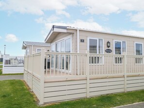 A single-story building with a white exterior, large windows, and a balcony. - 59 Cliff Field (Lowestoft)